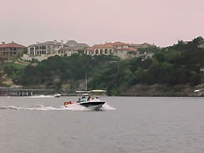 Boating past the houses along the shore of Lake Travis